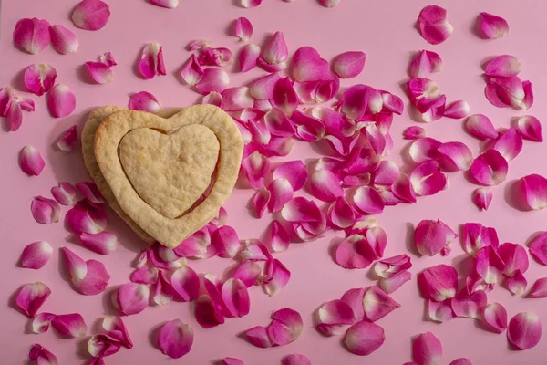 一颗大心脏里的一颗小心脏 背景是粉色的 周围是玫瑰花瓣 — 图库照片
