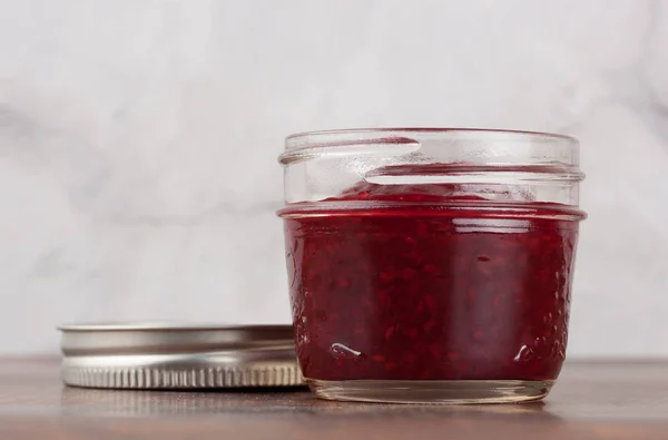 自制覆盆子果酱在可重复使用的玻璃瓶中 图库图片