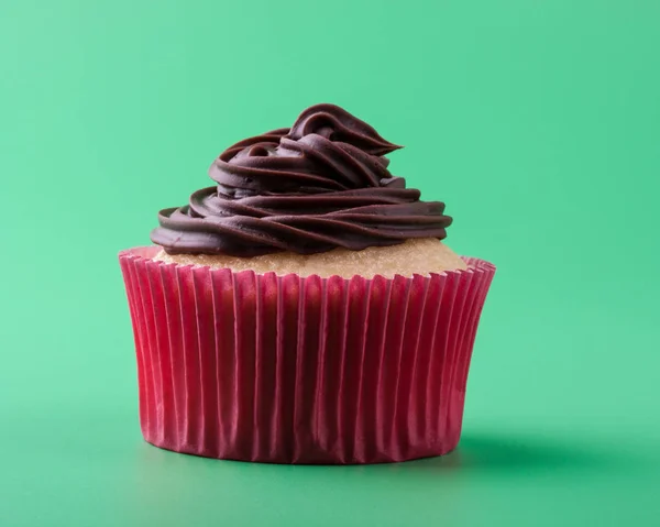 Lahodný Domácí Sladký Vanilkový Košíček Čokoládovou Polevou Zelené Pozadí — Stock fotografie