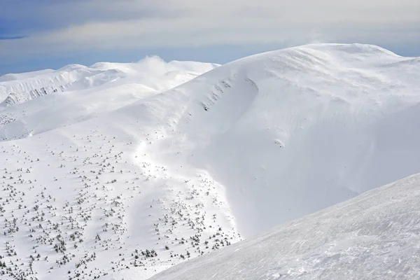 Bir dağ manzarası içinde bir yamaca kış — Stok fotoğraf