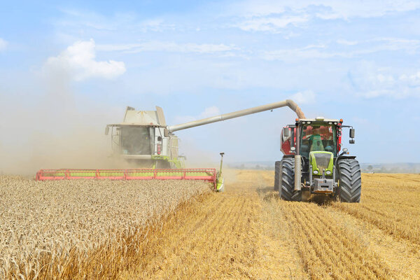 Overloading grain harvester into the grain tank of the tractor trailer
