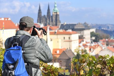 PRAGUE, CZECH REPUBLIC - 30 Ekim 2019: Turist şehrin muhteşem şehir manzaralarının fotoğrafını çekti.