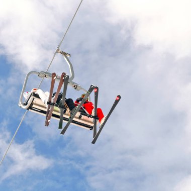 Bukovel (kayak merkezi ve spa), Ukrayna - 23 Şubat 2019: Gökyüzüne karşı bir sandalyede kayak asansöründe konukların.