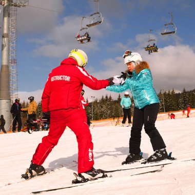 Bukovel (kayak merkezi ve spa), Ukrayna - 23 Şubat 2019: Kayak hocası acemi bir kayakçıyla bireysel bir ders yürütüyor.