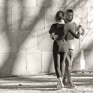 PRAGUE, CZECH REPUBLIC - October 30, 2019: Man and woman on Streletsky island under the bridge learning a new dance. Black and white photo.