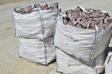 İnşaat alanında granit bloklu esnek orta büyüklükte bir konteynır (Fibc).