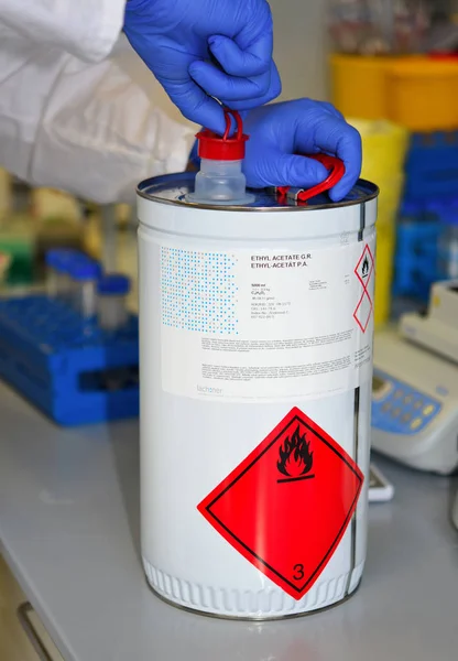 捷克共和国布拉格 2018年4月28日 一名实验室雇员 在工作表面附近的一个金属罐中安装易燃液体 醋酸乙酯有机和生物化学研究所 图库照片