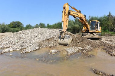 Kalush, Ukraine - July 8: Loading boulders in the car body on the construction of a protective dam near the town of Kalush, Western Ukraine July 8, 2015 clipart