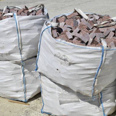 İnşaat alanında granit bloklu esnek orta büyüklükte bir konteynır (Fibc).