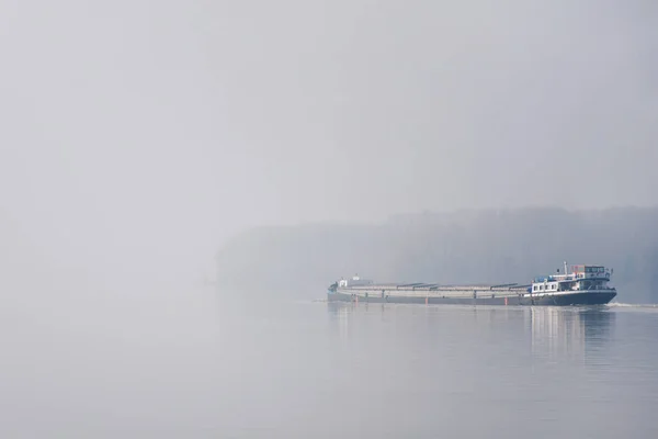 Floating cargo shipping barge into deep fog