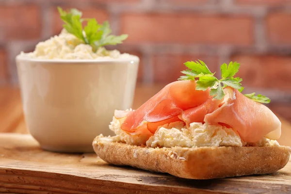 Smörgås med vita keso och skinka på trä bakgrund — Stockfoto