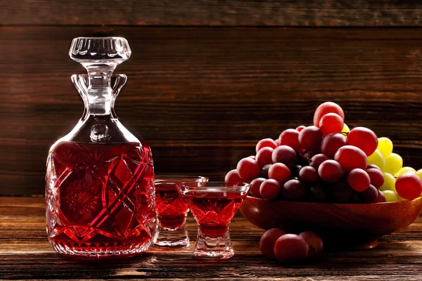 Red wine carafe and wine glass on wooden vintage background