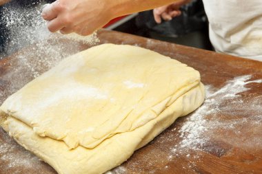 un hamur haddeleme için masanın üzerine döktü baker