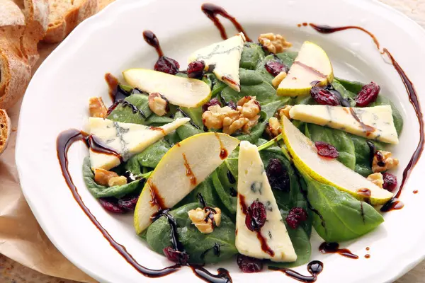 Салат из шпината с грушей, грецкими орехами и голубым сыром — стоковое фото