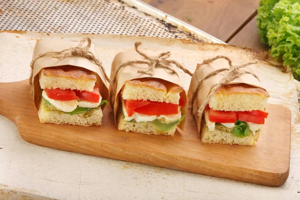 Сэндвич с моцареллой с базиликом и помидорами на деревянном боа — стоковое фото