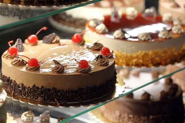 Different types of cakes in pastry shop glass display 