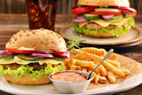 Čerstvé chutné burger s hranolky a pití na dřevěný stůl — Stock fotografie