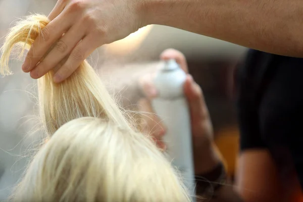 Hairdresser arranging hairdo using hairspray — Stock Photo, Image