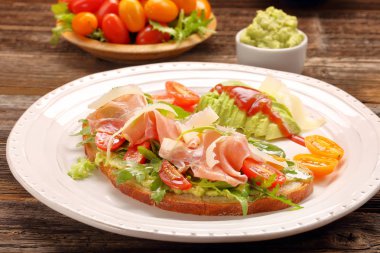 Roka ham domates ve chee ile taze ekmek üzerinde avokado sandviç