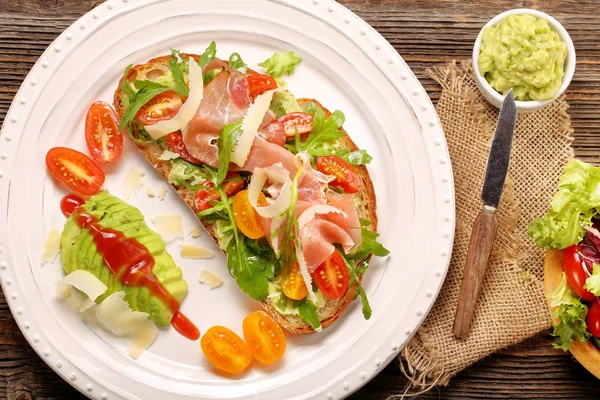 Sandwich à l'avocat sur pain frais avec jambon de roquette tomate et fromage — Photo