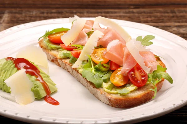 Avocado-Sandwich auf frischem Brot mit Rucola-Schinken Tomate und Käse — Stockfoto