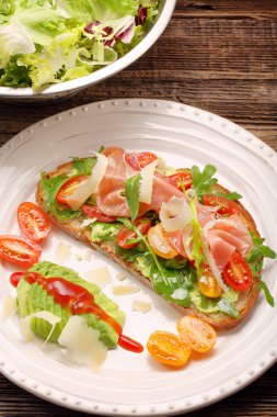 Roka ham domates ve chee ile taze ekmek üzerinde avokado sandviç