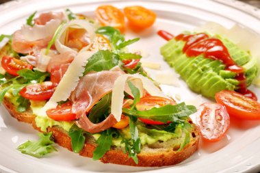 Roka ham domates ve chee ile taze ekmek üzerinde avokado sandviç