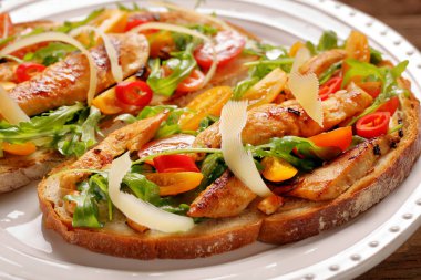 Tavuklu sandviç roka domates ve peynirli taze ekmek üzerinde