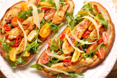 Tavuklu sandviç roka domates ve peynirli taze ekmek üzerinde