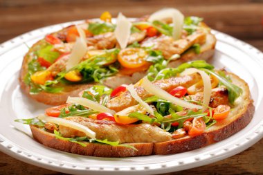 Tavuklu sandviç roka domates ve peynirli taze ekmek üzerinde