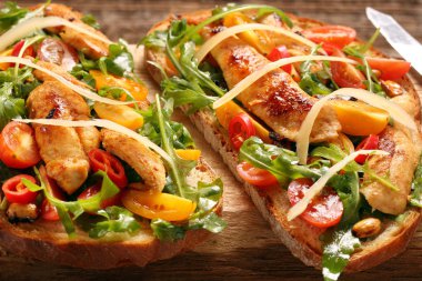 Tavuklu sandviç roka domates ve peynirli taze ekmek üzerinde