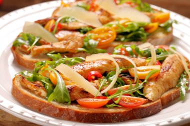 Tavuklu sandviç roka domates ve peynirli taze ekmek üzerinde