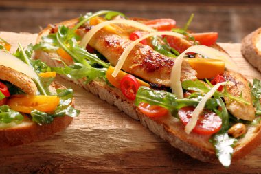 Tavuklu sandviç roka domates ve peynirli taze ekmek üzerinde