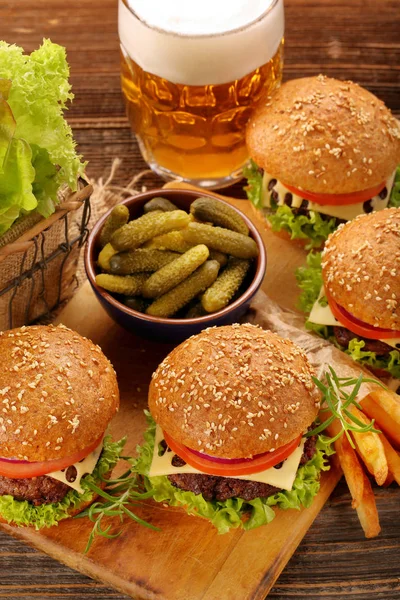 Hamburguesa con carne de res y verduras frescas sobre fondo de madera —  Fotos de Stock