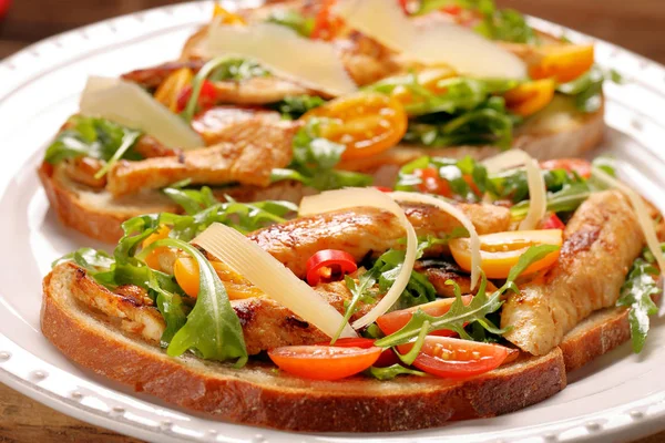 Tavuklu sandviç roka domates ve peynirli taze ekmek üzerinde