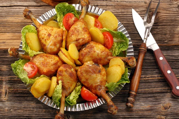 Chicken legs and baked dill potatoes with vegetable salad — Stock Photo, Image