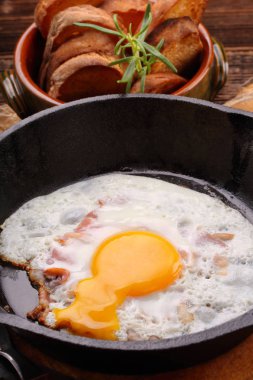 Sahanda yumurta ile bir tavada domuz pastırması parçaları