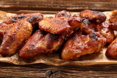 Ahşap arka plan üzerinde bir tavada pişmiş tavuk kanadı