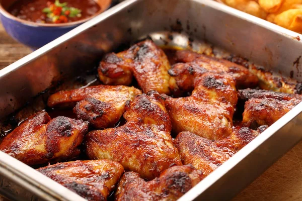 Chicken wings with baked potatoes and barbecue sauce — Stock Photo, Image