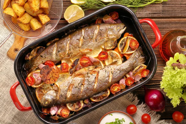 Gebakken vis met groenten en aardappelen in de pan — Stockfoto