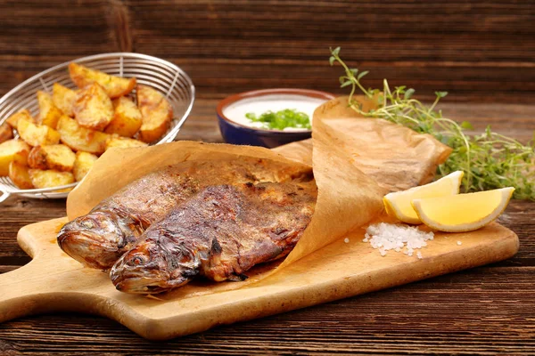 Baked fish with potatoes and white dip — Stock Photo, Image