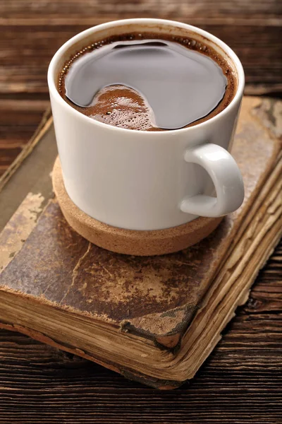 Παλιό βιβλίο και φλυτζάνι καφέ σε φόντο ξύλινη — Φωτογραφία Αρχείου
