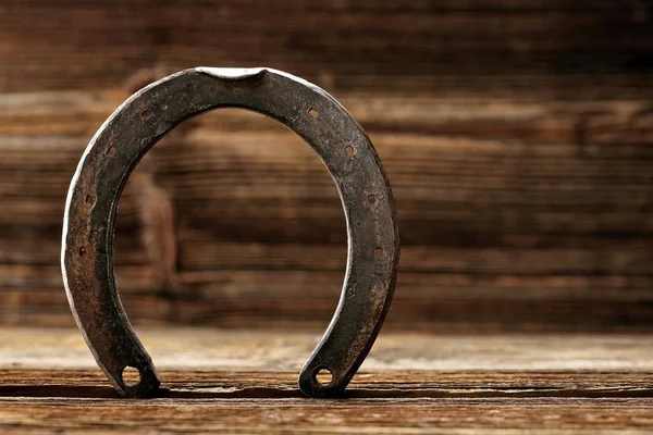 Vecchio ferro di cavallo arrugginito su sfondo di legno — Foto Stock