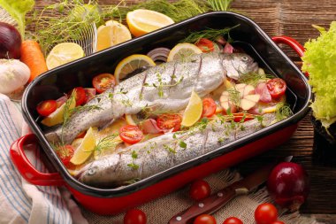Çiğ balık pişirmeye hazır bir tavada sebze ile