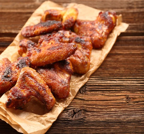 Chicken baked wings on wooden background — Stock Photo, Image