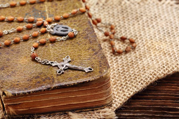 Very old prayer book and vintage rosary on wooden background — Stock Photo, Image