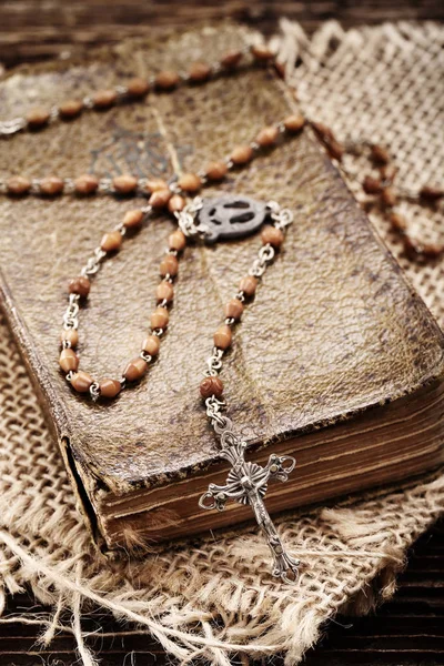 Very old prayer book and vintage rosary on wooden background — Stock Photo, Image