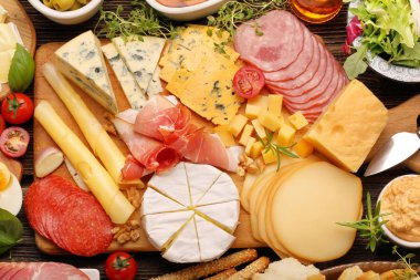 buffet of various types of cheese and appetizers set clipart
