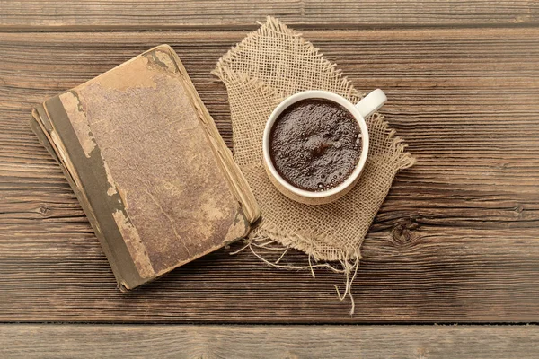 Старая книга и чашка кофе на старинном деревянном фоне — стоковое фото