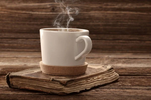 Gammal bok och kopp kaffe på vintage trä bakgrund — Stockfoto